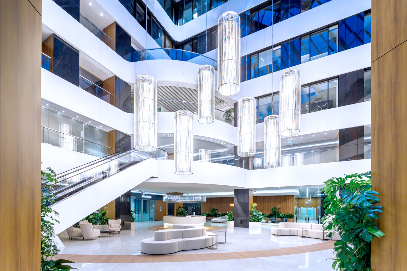 An image of a large indoor space with bright lighting and multiple floors with escalators
